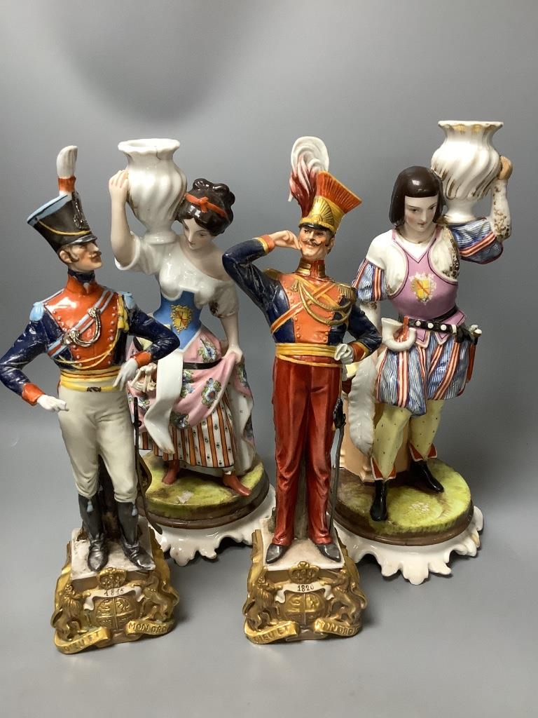 A pair of Italian porcelain figures and a pair of Continental figural candlesticks